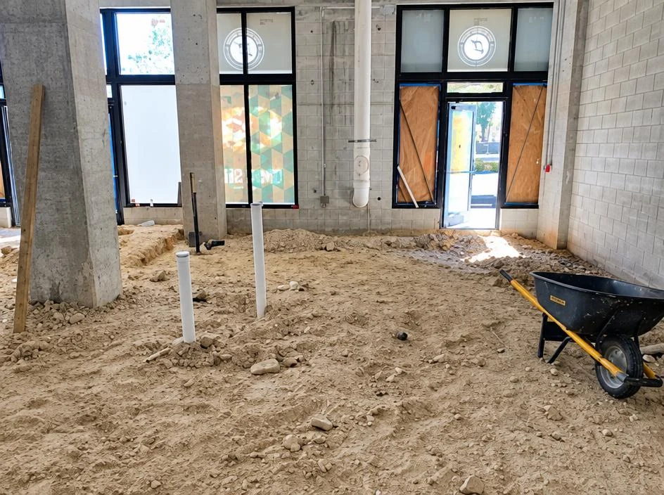Baked Bear — bare shell interior with a sandy floor during construction