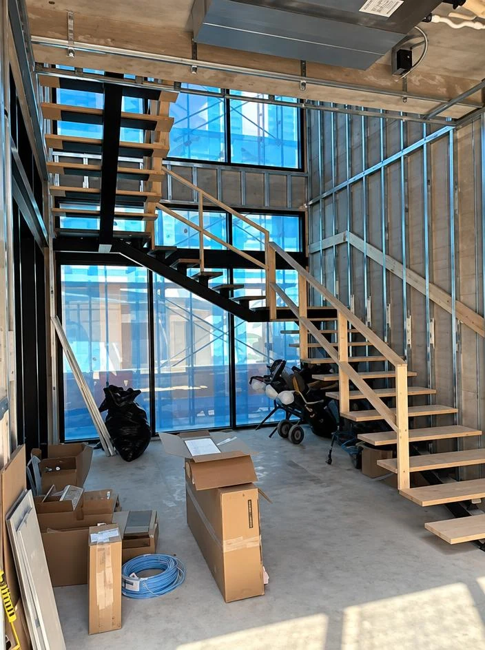Custom Home — interior stair and floor-to-ceiling glass walls during construction